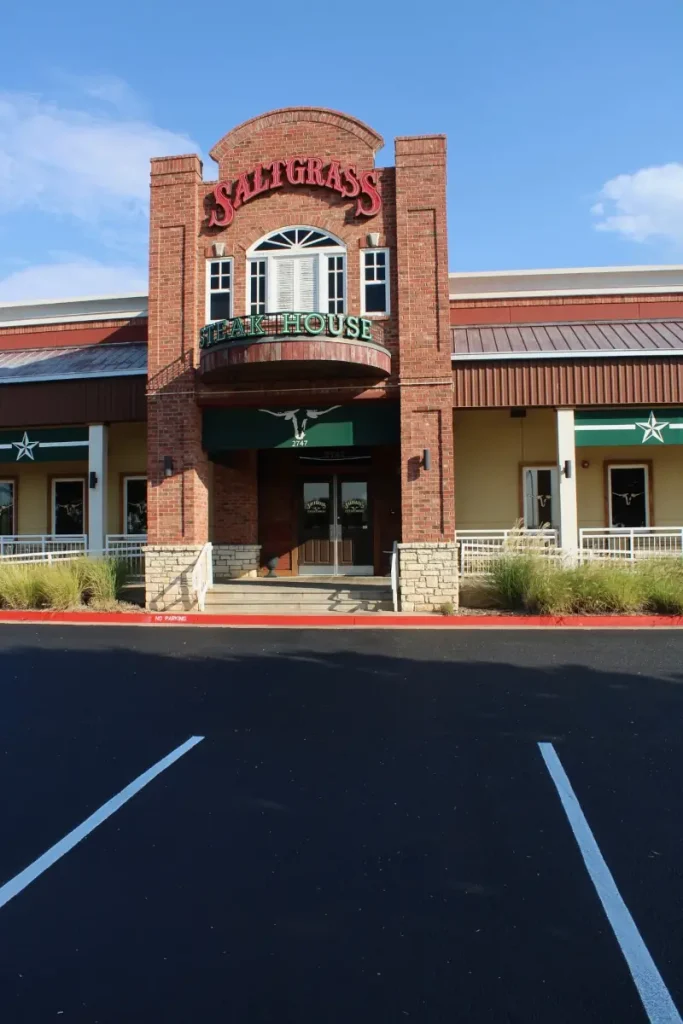 Front entrance of Saltgrass Steak House in Oklahoma City with freshly sealcoated and striped asphalt parking lot.